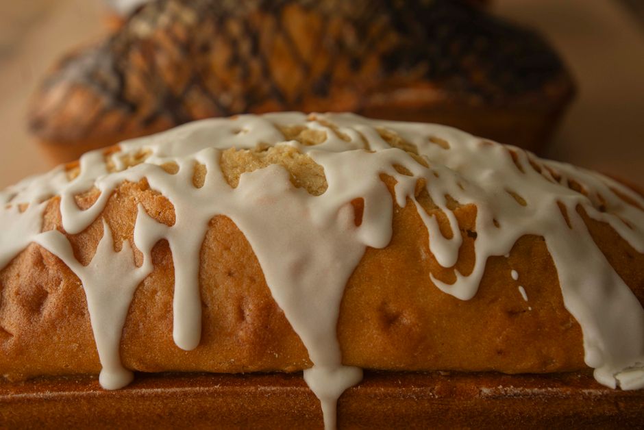 Ultimate Iced Banana Bread Recipe: Moist, Sweet, and Easy to Make 1 A beautiful slice of iced banana bread on a rustic plate, showing the moist crumb and thick vanilla glaze dripping down the sides.