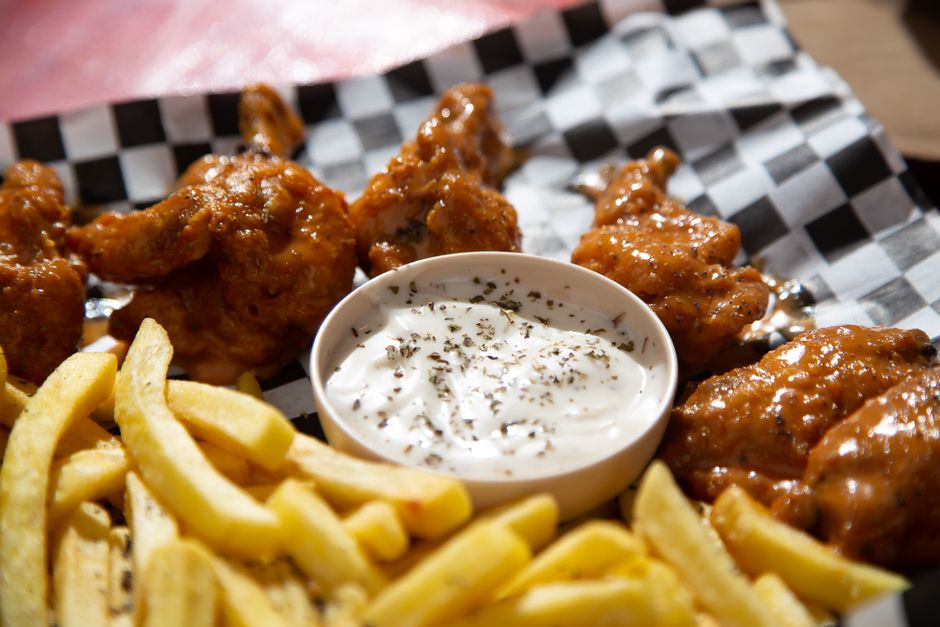 Sports Page Ashland Menu: The Ultimate Dining Guide & Copycat Recipe 3 A close-up of crispy, sauce-coated chicken wings with blue cheese dip