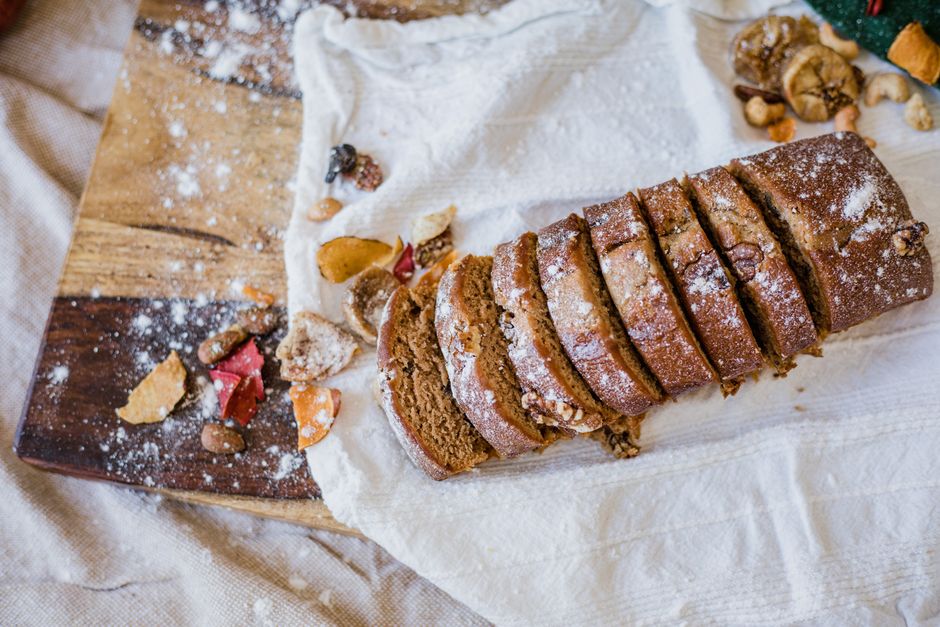 A close-up shot of a freshly sliced loaf of banana bread showing its moist, tender crumb texture on a wooden cutting board
