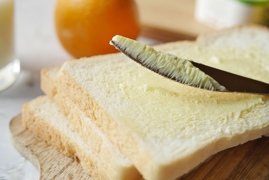 A close-up shot of a slice of pineapple banana bread toasted and spread with melting salted butter.