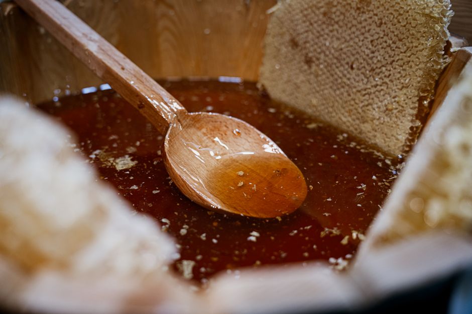 Moist Banana and Honey Bread Recipe - Naturally Sweetened 2 A close-up shot of raw honey being drizzled from a wooden dipper into a bowl of mashed bananas.