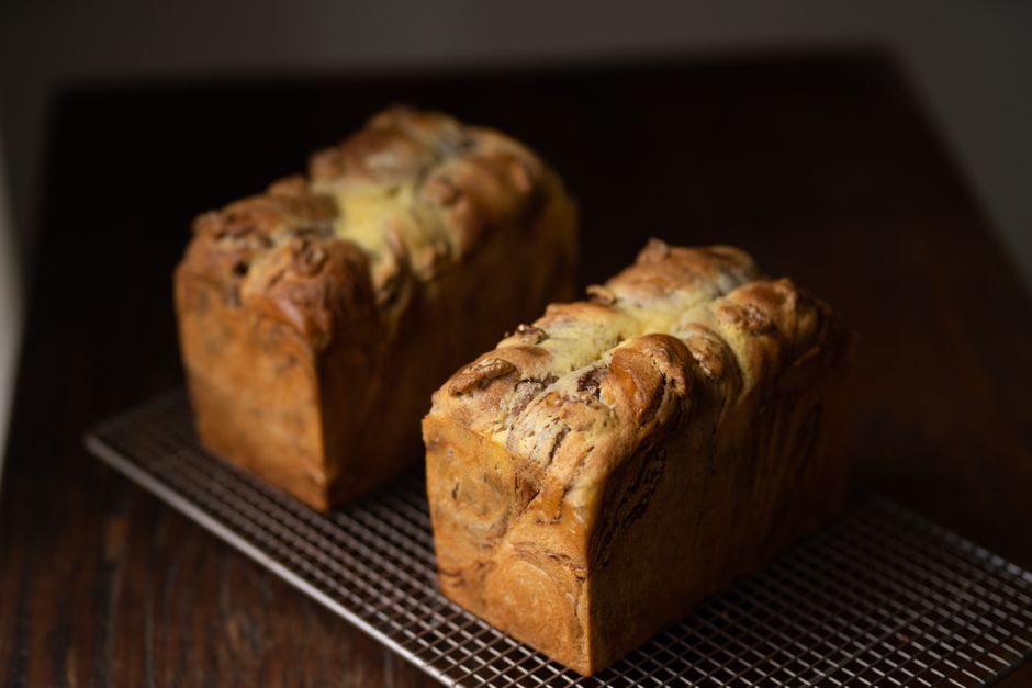 A freshly baked loaf of banana bread cooling on a wire rack, showing a golden brown crust and a beautiful center split