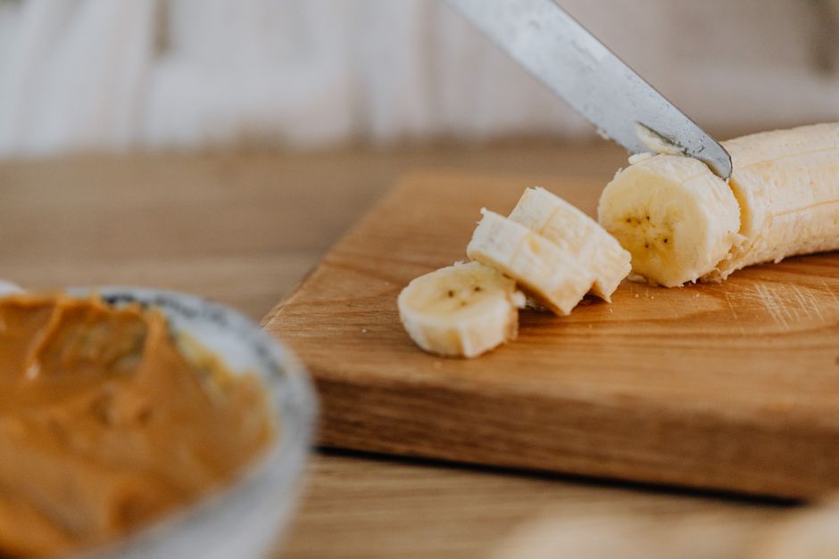 Moist Banana and Peanut Butter Bread Recipe - The Ultimate Comfort Bake 1 A freshly sliced loaf of banana and peanut butter bread on a wooden cutting board, with steam rising and a smear of peanut butter on one slice