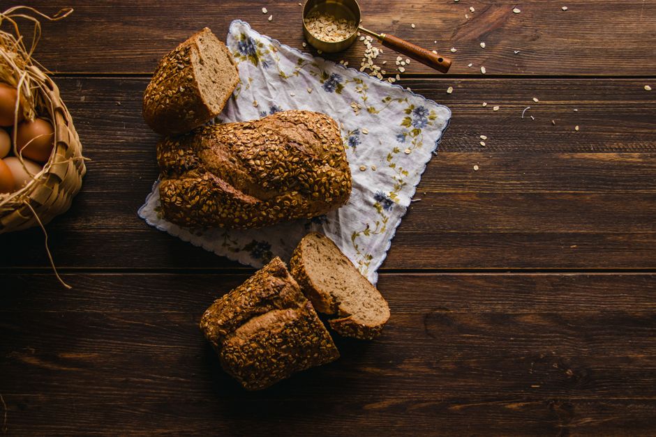 Healthy Banana Bread Recipe with Oats: Easy, Moist, and Naturally Sweet 1 A rustic wooden table featuring a freshly baked loaf of oat banana bread, sliced to show the moist interior texture, surrounded by raw rolled oats and ripe bananas