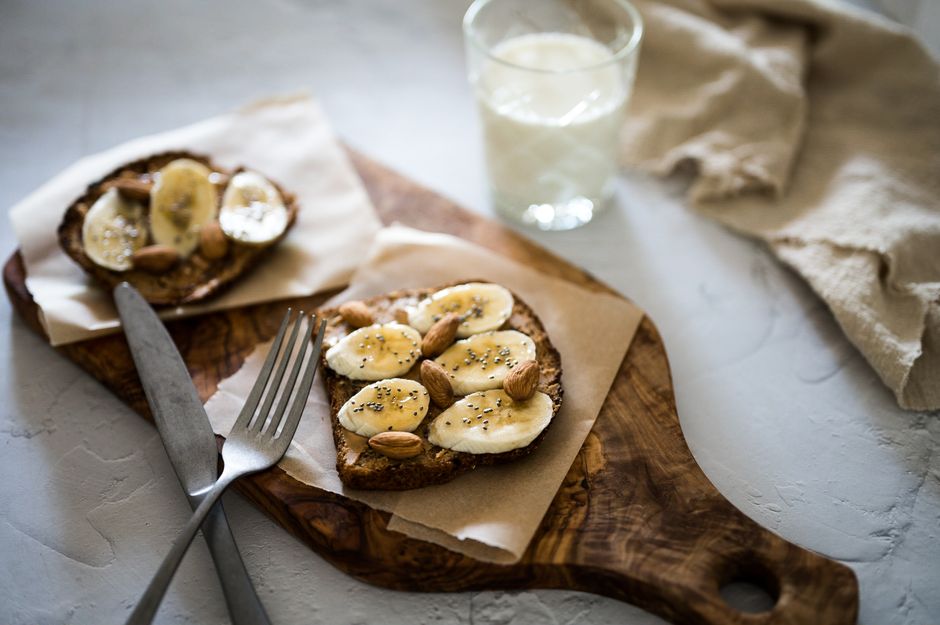 A slice of flourless banana bread toasted and topped with a smear of almond butter and fresh banana slices