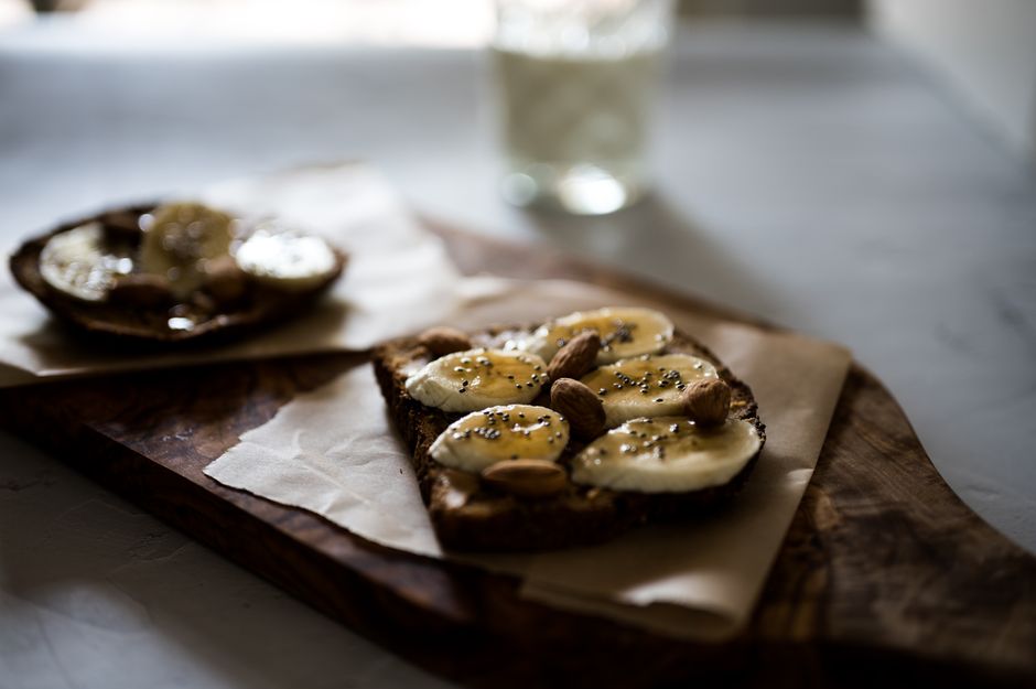 A slice of toasted banana spice bread topped with a melting pat of salted butter and a drizzle of honey
