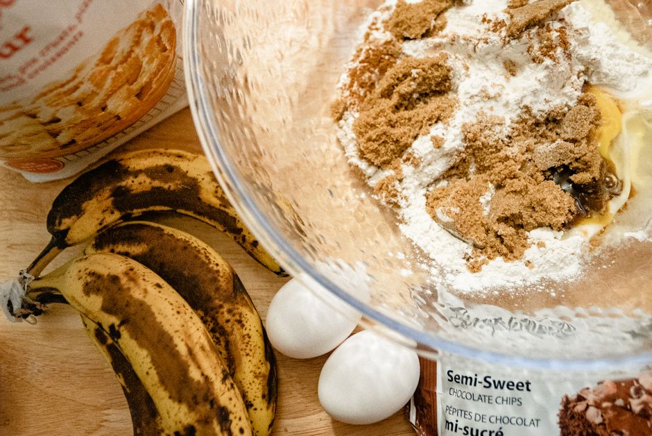 Ingredients gathered on a kitchen counter: overripe bananas, a box of yellow cake mix, eggs, and vegetable oil.