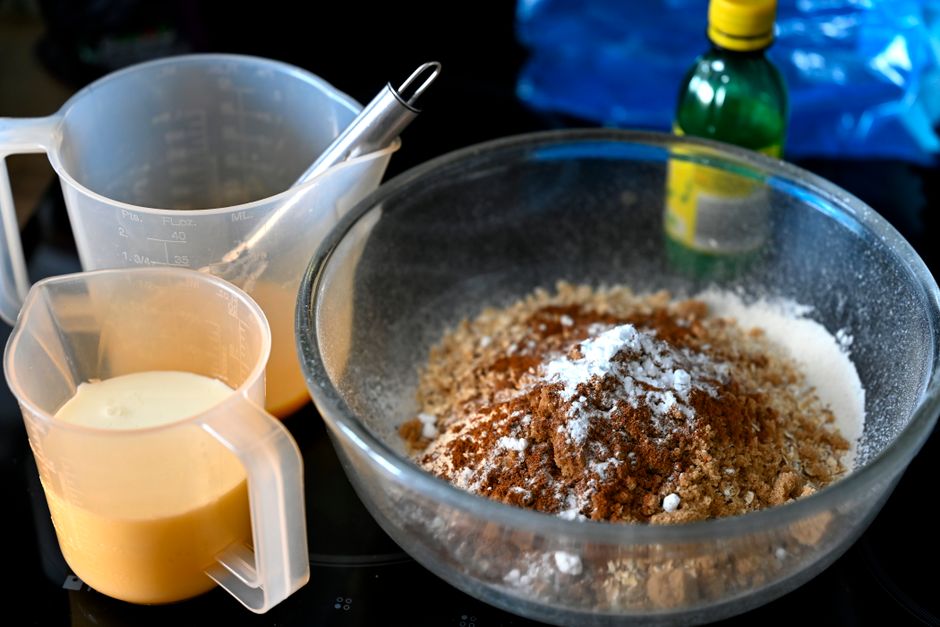 Ultimate Iced Banana Bread Recipe: Moist, Sweet, and Easy to Make 2 Overripe bananas being mashed in a glass bowl next to a measuring cup of flour and a bowl of creamy icing.