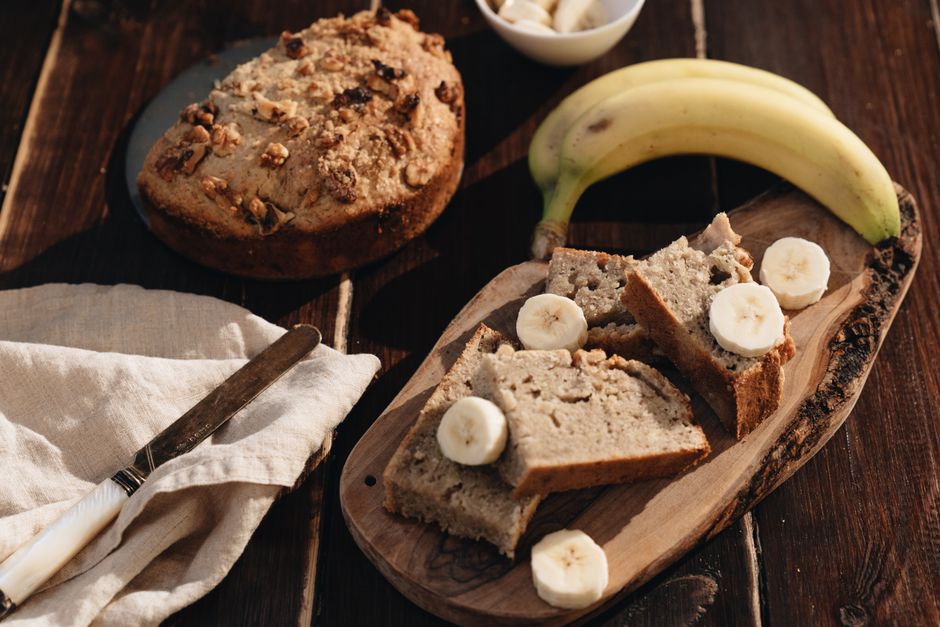 Sliced flourless banana nut bread on a wooden board