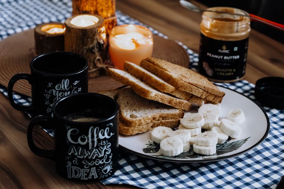 Slices of banana nut bread served with a pat of melting butter and a cup of hot coffee