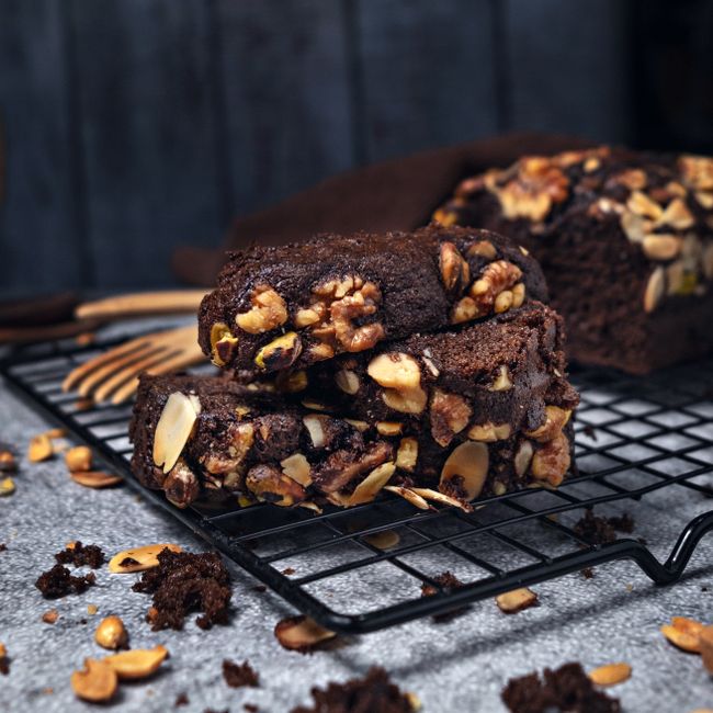 Healthy Chocolate Chip Banana Bread Recipe - Moist & Wholesome 3 Slices of customized banana bread topped with walnuts, extra chocolate chips, and a drizzle of almond butter.