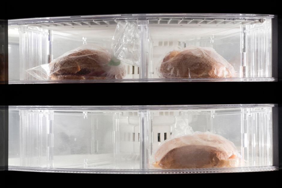Slices of nut-free banana bread wrapped individually in plastic wrap, ready to be stored in the freezer for quick breakfasts.